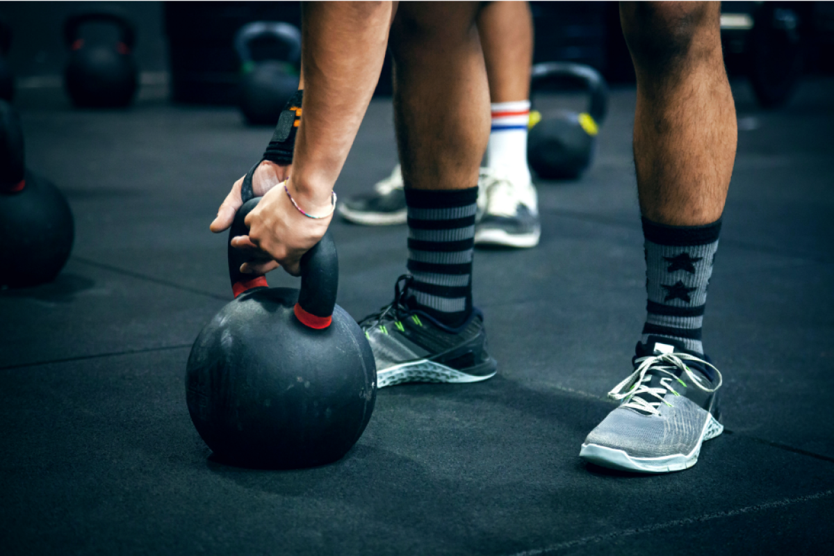 An image of individuals performing strength training exercises outdoors, such as kettlebell swings